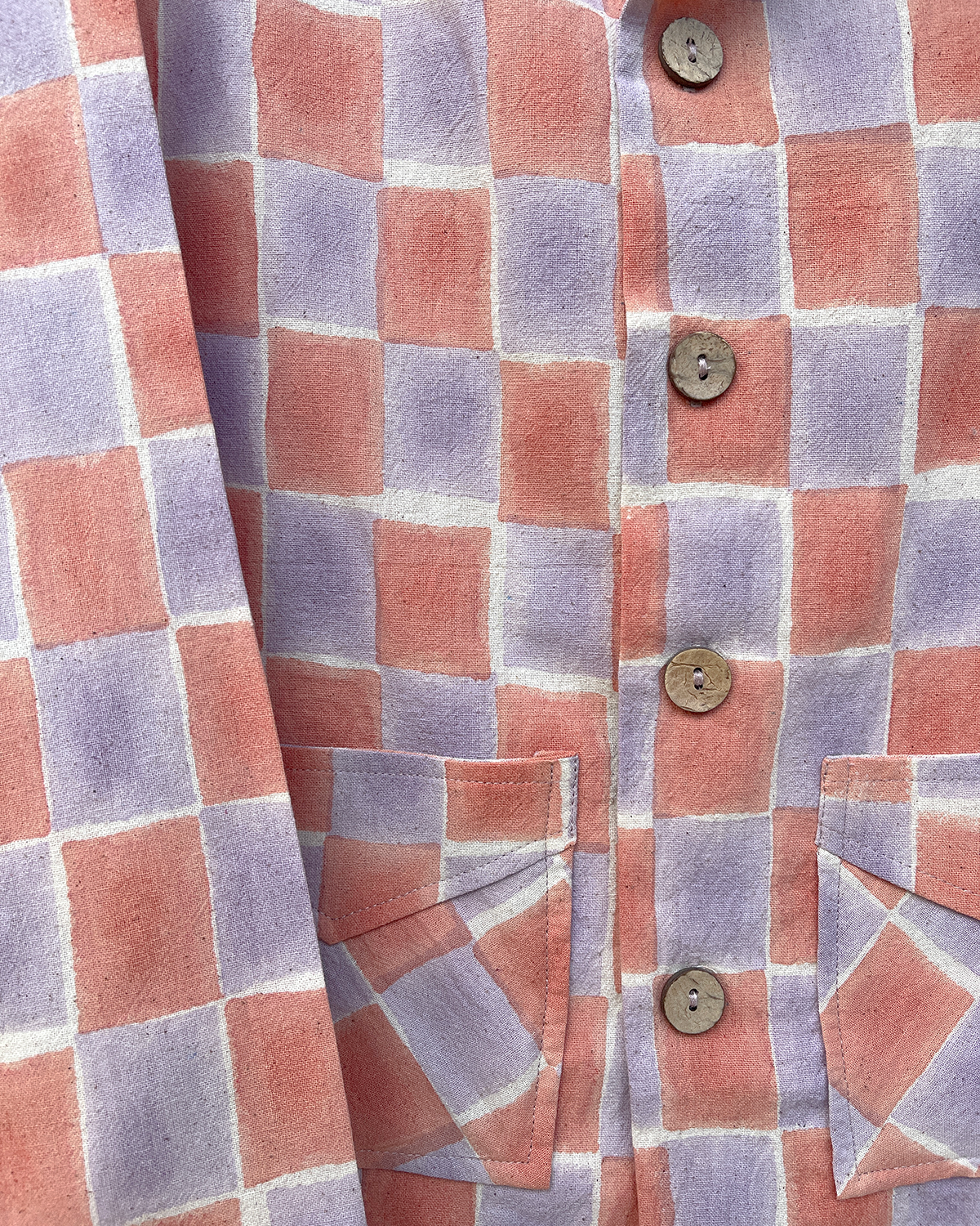 Close-up detail of the Sala block-print on handwoven cotton. The pattern shows artful, hand-printed vertical boxes in shades of pink and lavender, highlighting the unique texture of the handloom fabric.