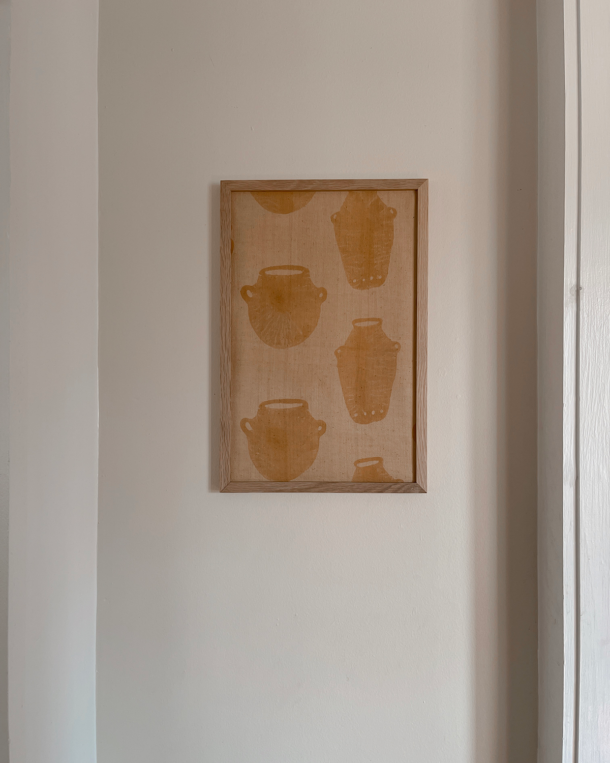 Framed artwork with abstract designs on a plain wall