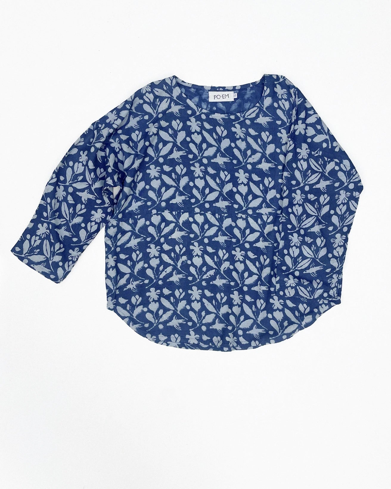 Front view of the PO-EM oversized indigo tunic in the Sky-garden print. A one-size, boxy-cut top made from handwoven cotton with a split front seam and long rollable sleeves.